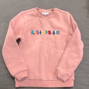 Pink Lacoste crewneck sweatshirts.
